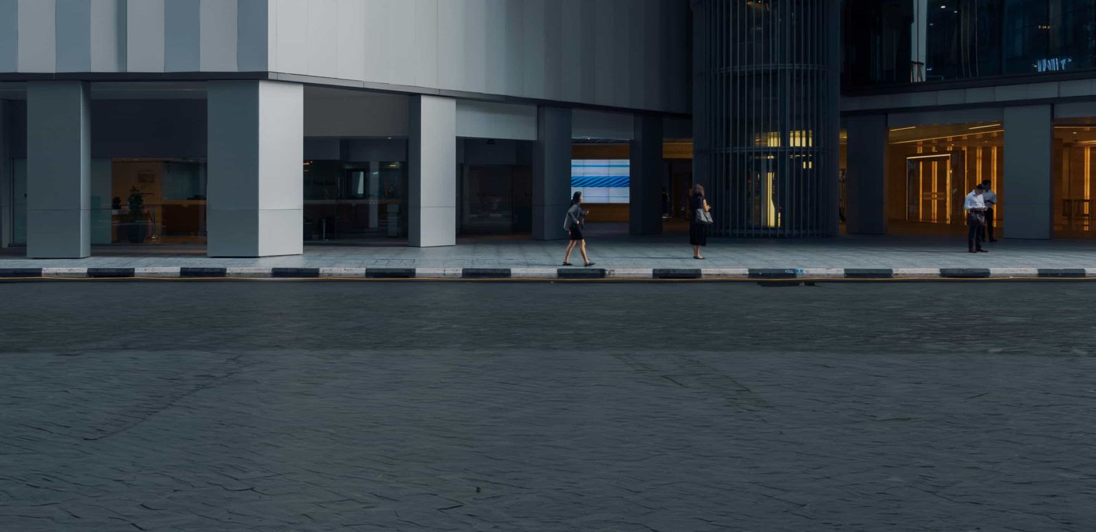 people walking in front of an office block