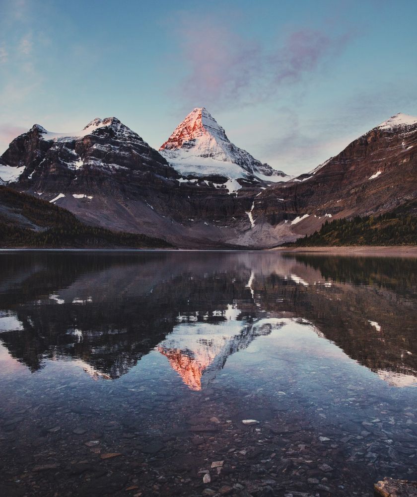 a clear lake with mountains in the background