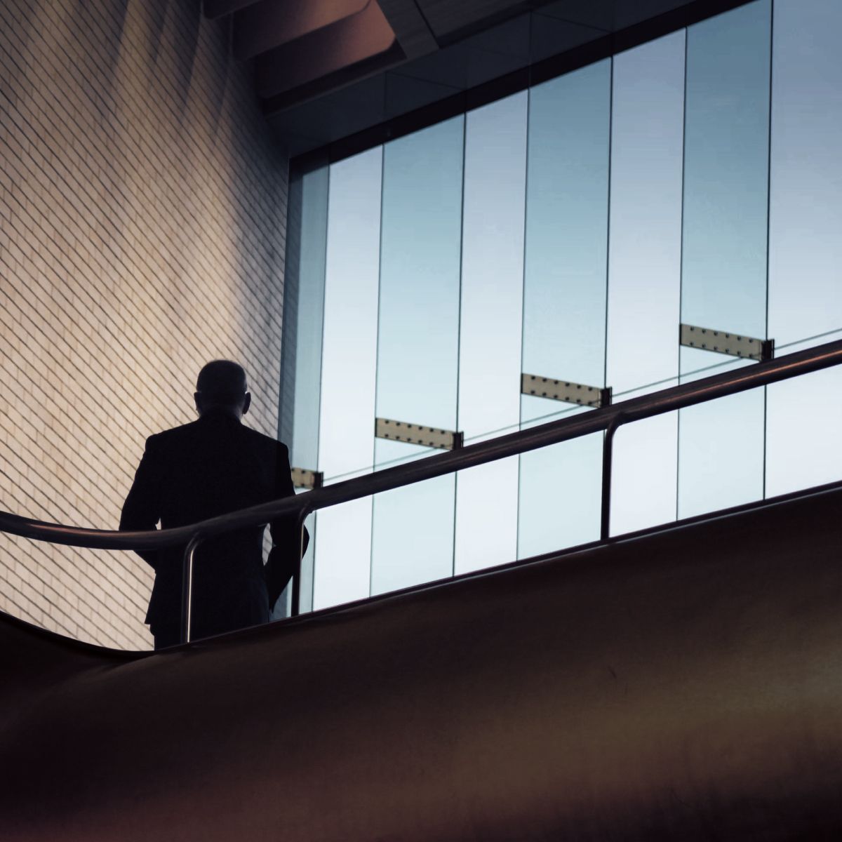 a person in the stairwell of an office looking out the window